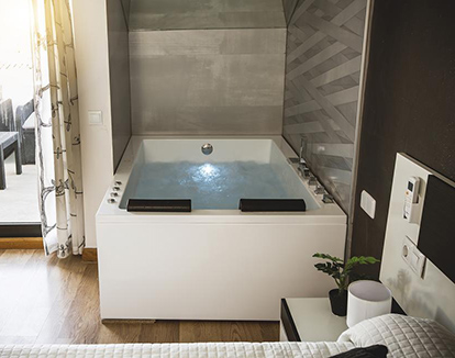 Foto de la la Habitación Deluxe con cama grande donde se encuentra la bañera de hidromasaje