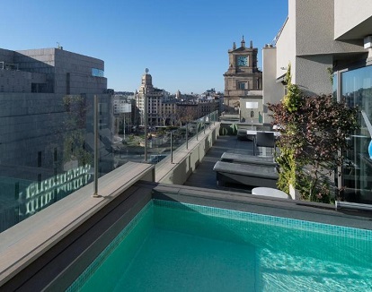 Foto de la Suite Junior con piscina privada en la terraza donde tienes además unas tumbonas con vistas a la ciudad de Barcelona