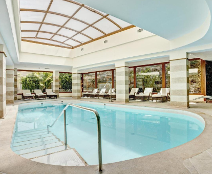 Foto de la piscina cubierta climatizada con tumbonas