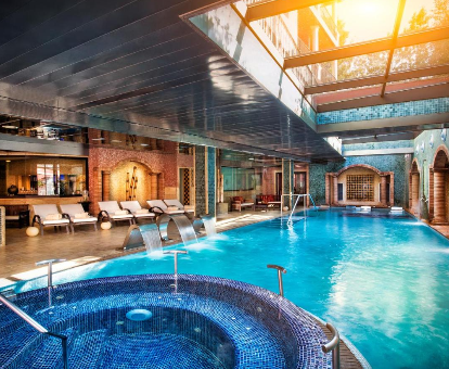 Foto de la piscina climatizada con bañera de hidromasaje y luz natural