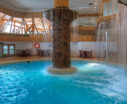 Foto de la piscina cubierta climatizada con cascadas de agua