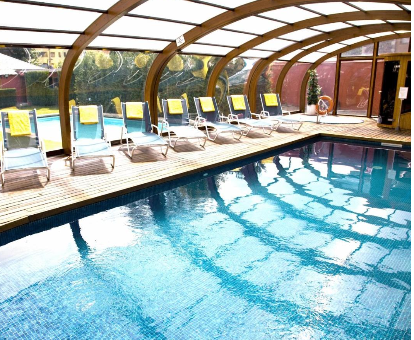 Foto de la piscina cubierta climatizada con tumbonas y luz natural