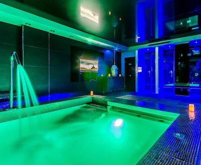 Foto del Spa del hotel de 5 estrellas Grand Hotel Don Gregorio con la piscina climatizada iluminada de color verde y con chorros de agua para hidroterapia.